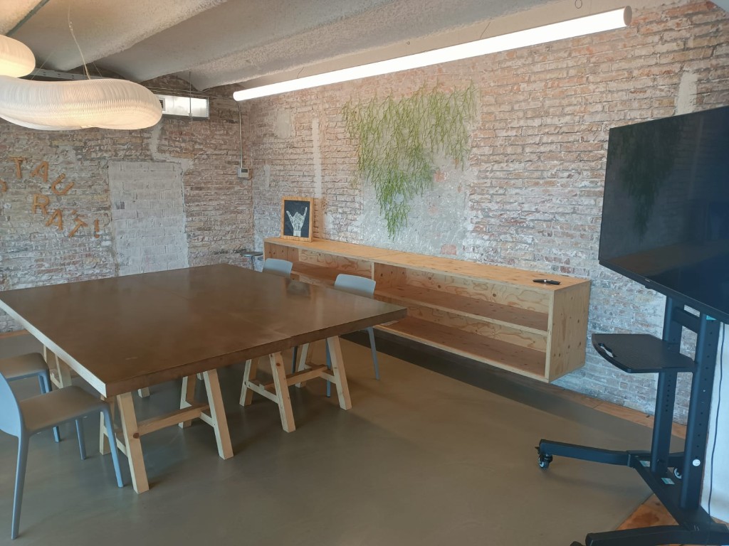 Session room at Pier07 with brick walls, communal table, chairs, and presentation screen